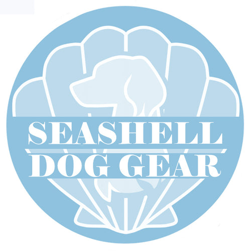 A pale blue circle with an outlined white seashell taking up the majority of the background, in front of the seashell is the white outline of a dog's bust (chest + head), the dog has long furry ears. 'SEASHELL DOG GEAR' is written in two lines across the centre of the circle, also in white.